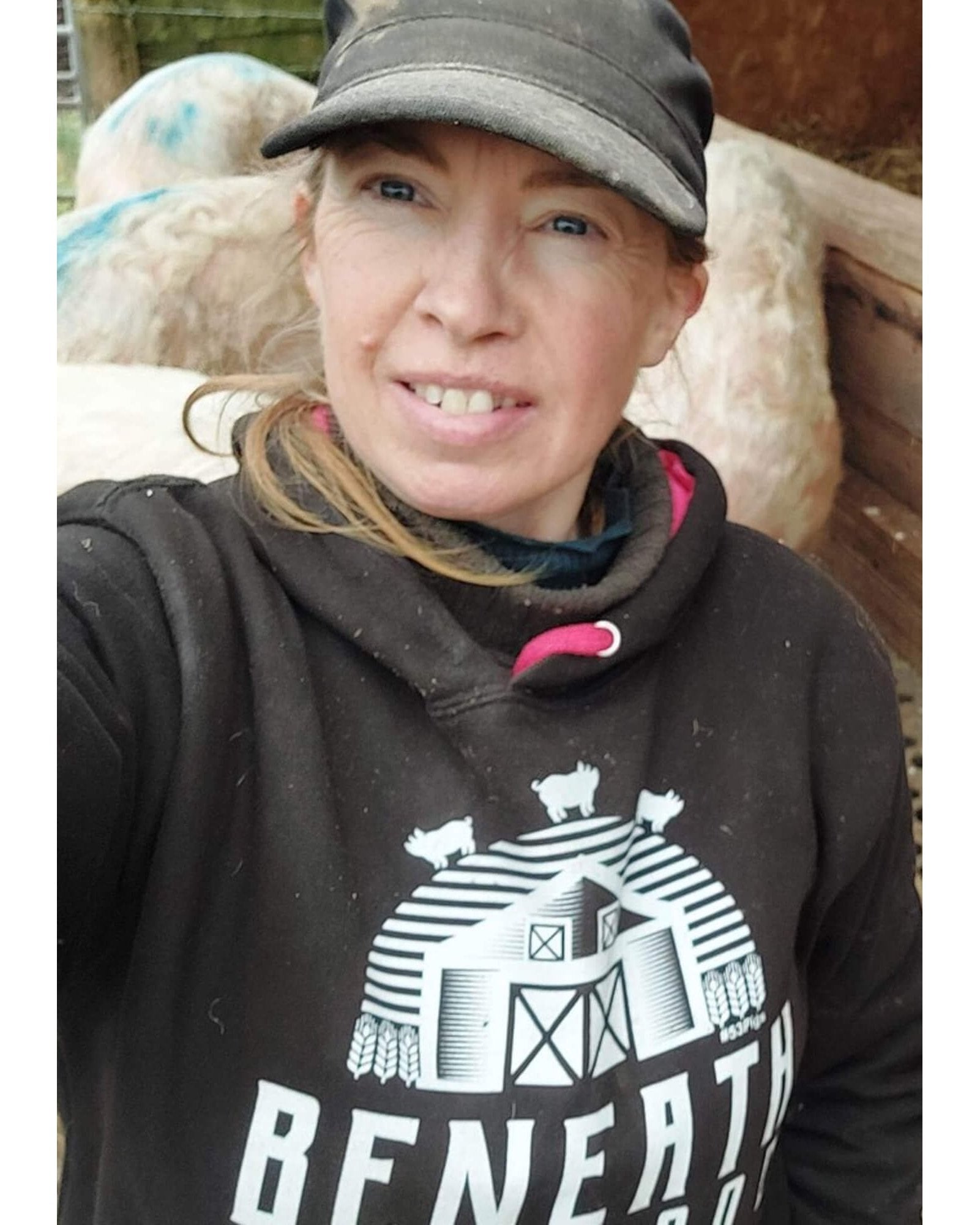Close up of Sasha wearing a black hoodie with white print & hot pink trims. By Viva La Vegan. Fund raising for Beneath The Wood Sanctuary