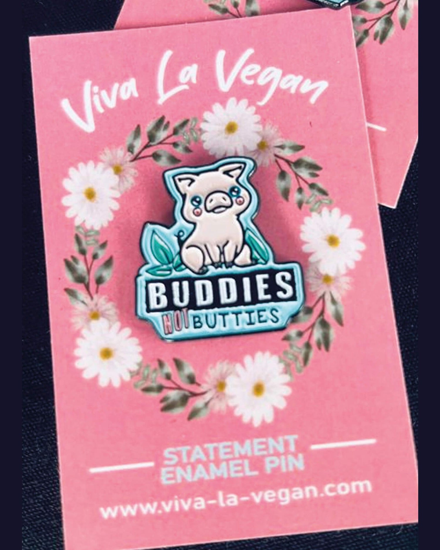 Pink pig pin on a turquoise background with the wording Buddies NOT Butties. By Eco ethical brand Viva La Vegan