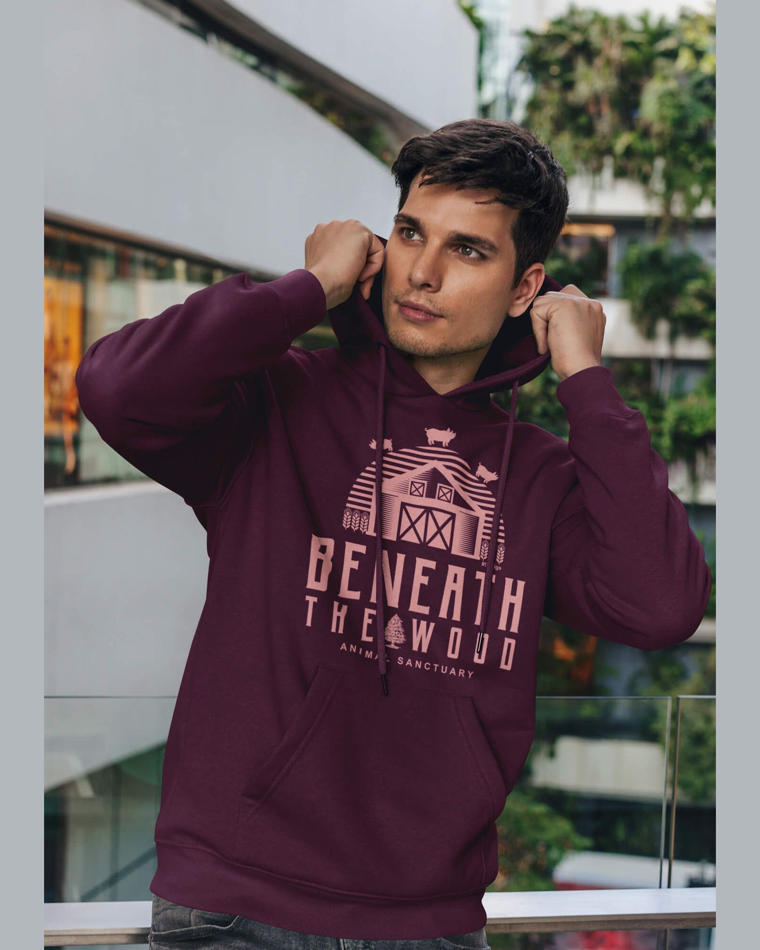 young man wearing a burgundy Beneath the wood logo hoodie
