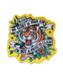 Embroidered patch featuring a roaring tiger surrounded by floral motifs and bold banners. Text reads: “Born Hunting / No Glory In Your Aim / I&