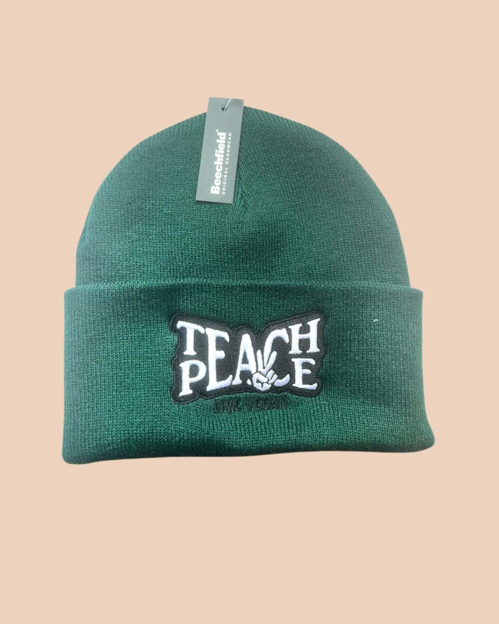 Flatlay photo of a cuffed beanie in Bottle green colour with a black and white embroidery &
