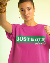 Short haired woman wearing a Just eats Plants T-shirt in hot pink