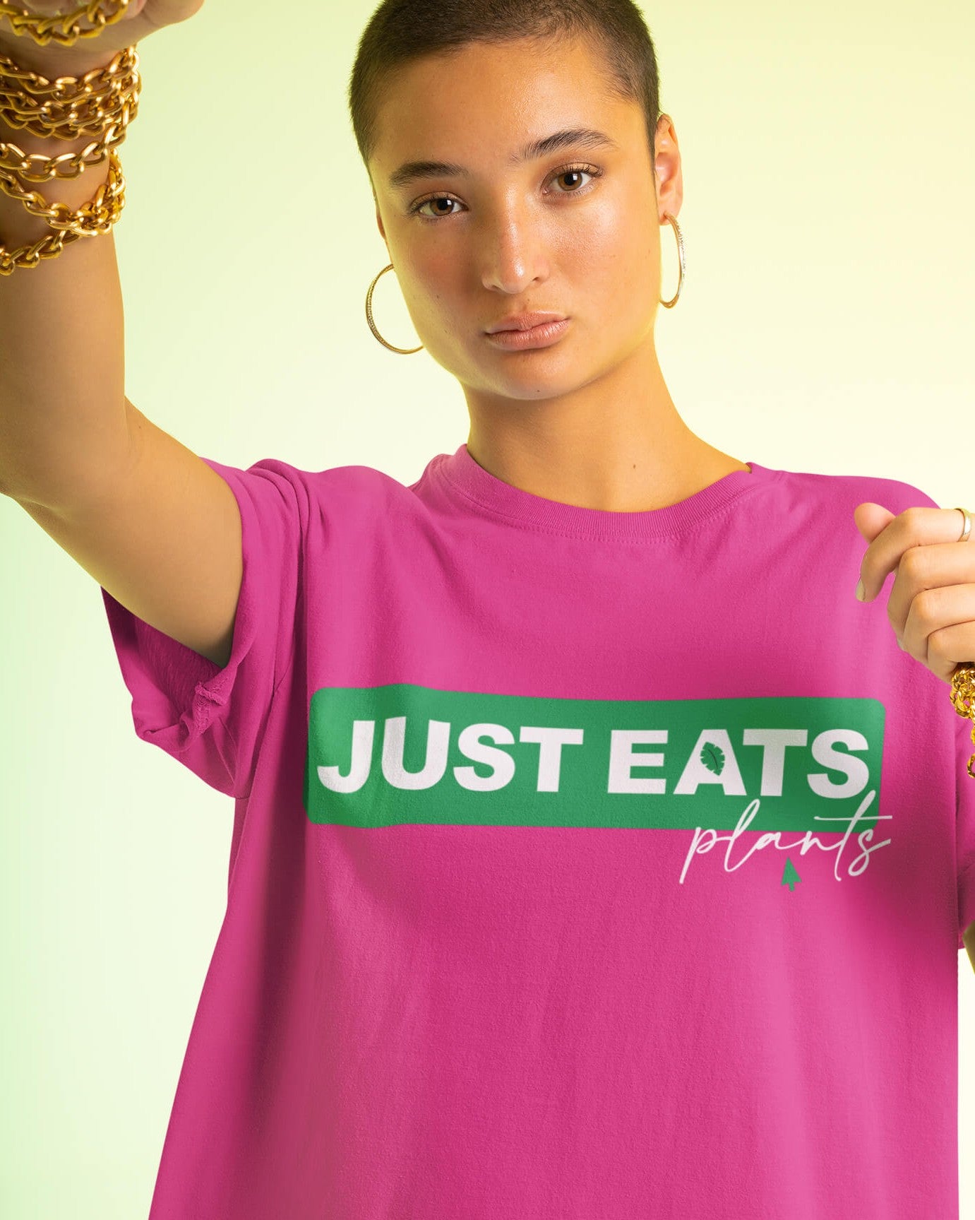 Short haired woman wearing a Just eats Plants T-shirt in hot pink