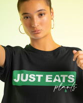 Short haired woman wearing an over sized Tshirt with the print Just Eats Plants