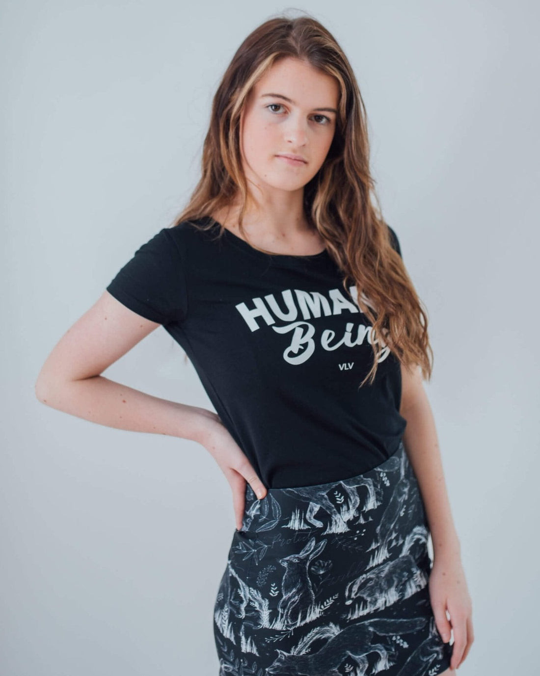 Vegan Model wearing all over animal print mini skirt matched with a humane being tshirt