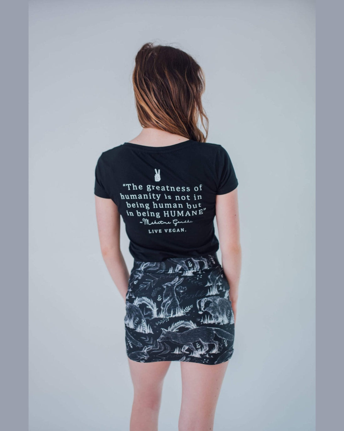 Vegan Model wearing all over animal print skirt back view