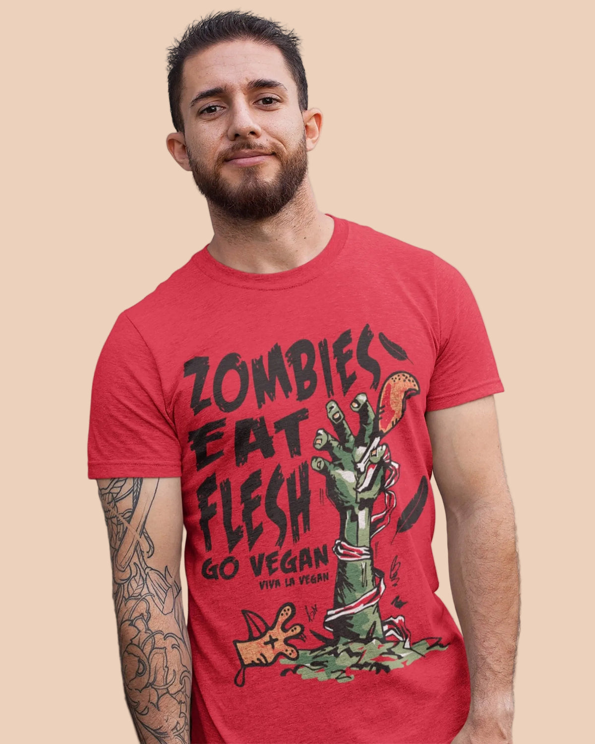 Male model standing against a wall and wearing Viva La Vegan's unisex tshirt Zombies eat flesh go vegan by viva la vegan